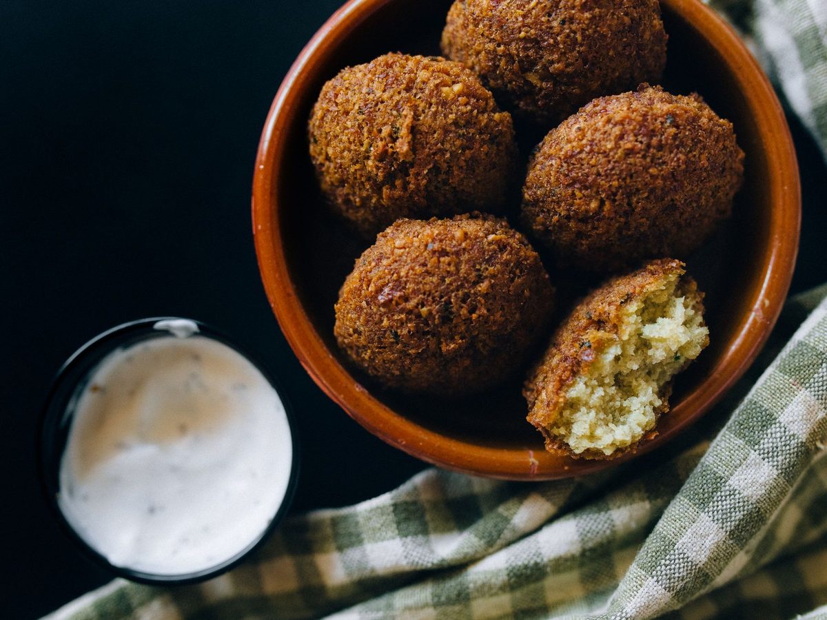 Falafel, crisp fried chickpea fritters with a green herbed centre, served with tahini