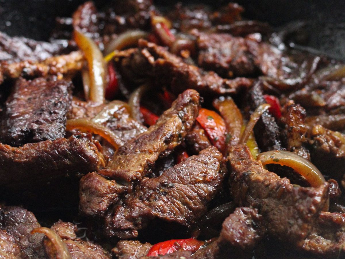 Filipino bistek, thin beef steaks in soy and calamansi smothered in soft onion rings